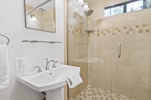 une salle de bain blanche avec lavabo et douche dans l'établissement Pinecone Escape - Close to Lake and Slopes, à Big Bear City 32 autres photos