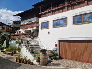 a white building with stairs and potted plants on it at Appartements Pension Sonia in Funes