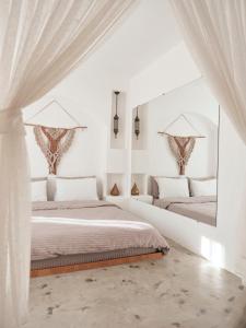 two beds in a white room with a mirror at Casa De Nova Hotel in Gümbet