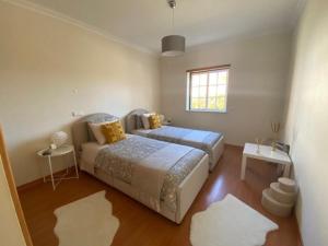 a bedroom with two beds and a window at Casa M Falésia in Albufeira