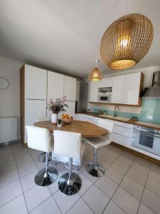a kitchen with a wooden table and white cabinets at Superbe T3 Chessy Disney/Paris - Jacuzzi, Jardin, Barbecue, Parking in Chessy