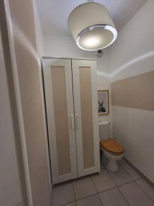 łazienka z toaletą z drewnianą deską i lampką w obiekcie Superbe T3 Chessy Disney/Paris - Jacuzzi, Jardin, Barbecue, Parking w mieście Chessy