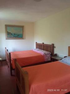 una camera con due letti con lenzuola rosse di Popetto casa vacanza a Tresana