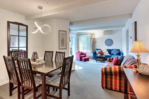 ein Wohnzimmer mit einem Tisch, Stühlen und einem Sofa in der Unterkunft Tremblant Mountain Resort Condo! in Mont-Tremblant