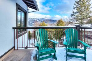 2 grüne Stühle auf einem Balkon mit Aussicht in der Unterkunft Tremblant Mountain Resort Condo! in Mont-Tremblant