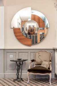 a mirror in a room with a chair and a table at L'Oiseau Bleu ROLLIER in Roubia +16 photos