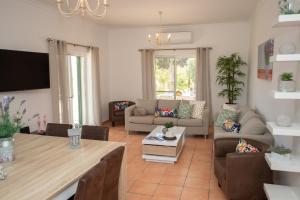 ein Wohnzimmer mit einem Sofa und einem Tisch in der Unterkunft VILLA CARACOL Heated Swim Spa & Mini-Golf in Luz de Tavira