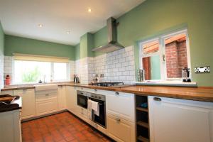 una cucina con armadi bianchi e pareti verdi di Lovely 2BR home with sunny garden in Montpelier a Bristol