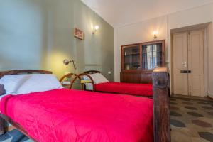 1 dormitorio con 2 camas con sábanas rojas y puerta en Vintage Apartment in Lingotto Area by Wonderful Italy, en Turín