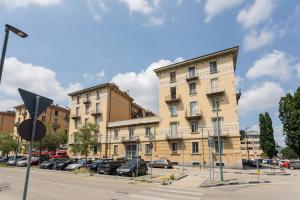 un gran edificio con coches estacionados en un estacionamiento en Vintage Apartment in Lingotto Area by Wonderful Italy, en Turín