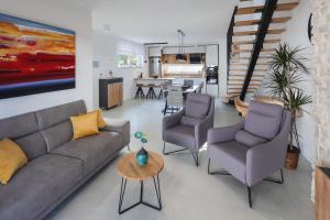 ein Wohnzimmer mit einem Sofa, 2 Stühlen und einem Tisch in der Unterkunft Villa Kaoru brand new Villa with a heated swimming pool in Malinska