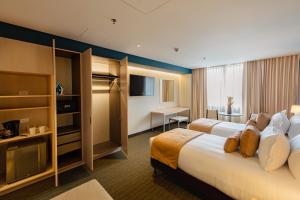 una camera d'albergo con due letti e una televisione di Liv Hotels a Bogotá