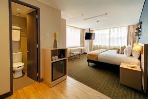 una camera d'albergo con letto e bagno di Liv Hotels a Bogotá