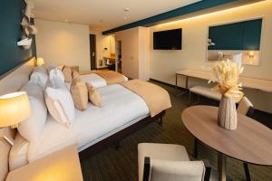 a hotel room with a large bed and tables and chairs at Hotel Faranda Collection Zona G in Bogotá +97 photos