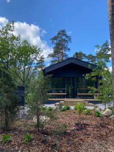 a pavilion with a black canopy in a forest at Tammikon Tupa in Tuusula