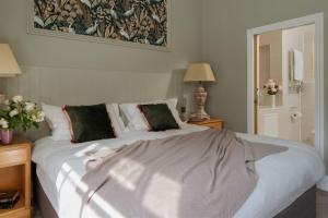a bedroom with a large white bed with two pillows at The Upper School House in Ashburton
