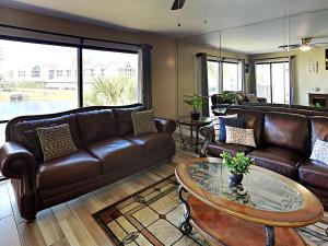 sala de estar con sofás de cuero y mesa en Edgewater Villa 2112, en Panama City Beach