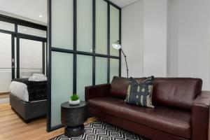 a living room with a couch and a bed at The Carrington Aparthotel by Totalstay in Cape Town