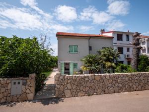 uma casa com uma parede de pedra e um edifício em Sunny side Apartments em Malinska