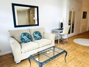 a living room with a couch and a table and a mirror at Perfect Location Whole Apartment With Wifi & Private Garden CONTRACTORS WELCOME in Southend-on-Sea