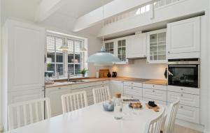 a white kitchen with a white table and chairs at 3 Bedroom Gorgeous Home In Gilleleje in Gilleleje