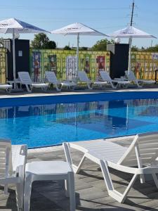 a group of chairs and umbrellas next to a swimming pool at Holiday stay Nika in Busk