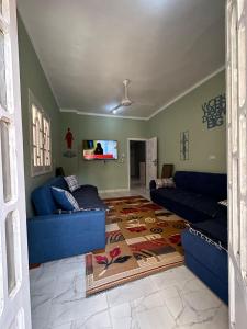 a living room with blue couches and a rug at Skylen Hostel in Hurghada
