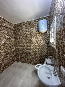 uma casa de banho com um lavatório e um WC em Skylen Hostel em Hurghada