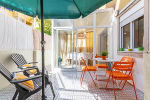 eine Terrasse mit einem Tisch, Stühlen und einem Sonnenschirm in der Unterkunft ALM- Spacious. Sunny. Patio. Quiet area. FAST WIFI in Lissabon