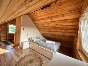 ein Schlafzimmer in einem winzigen Haus mit Holzwänden in der Unterkunft Domki na Mazurach - Marksewo in Szczytno