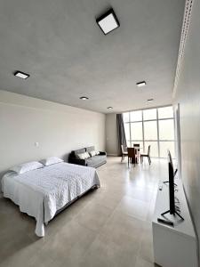 - une chambre avec un lit, un canapé et une table dans l'établissement Studio Residencial no coração do 4° Distrito, à Porto Alegre