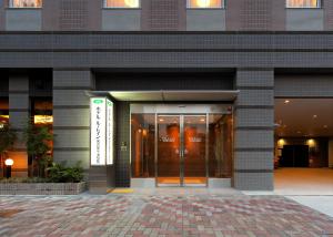 a building with a revolving door in front of it at Hotel Route-Inn Nagoya Imaike Ekimae in Nagoya