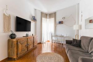 een woonkamer met een bank en een flatscreen-tv bij Seamoon Home Nettuno in Nettuno