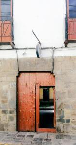 a red door in a brick building with a garage at Nishihouse in Cusco