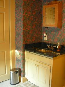 a bathroom with a sink and a mirror at Antique Mansion B & B in Rutland
