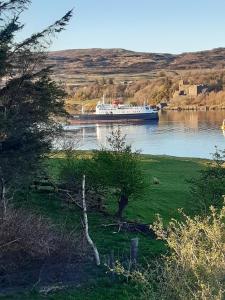 a large boat in the water on a river at Castle View Apartment in Dunvegan