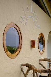 pared con 2 espejos y silla en una habitación en Tierra Munay, en Las Tunas