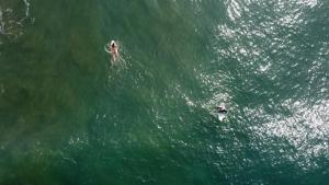 dos personas en tablas de surf en un gran cuerpo de agua en Tierra Munay, en Las Tunas