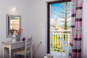 a desk and a mirror in a room with a window at Theodora Studios in Argassi