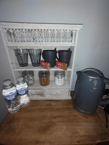 - une étagère avec des pots, des bols et des bouteilles d'eau dans l'établissement Double Room close to EFC LFC Liverpool City Centre, à Liverpool