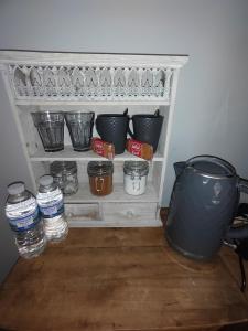 a shelf with pots and bowls and water bottles at Double Room close to EFC LFC Liverpool City Centre in Liverpool
