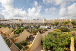 een appartementencomplex met een parkeerplaats en een gebouw bij Unik Heliopolis naturiste in Cap d'Agde