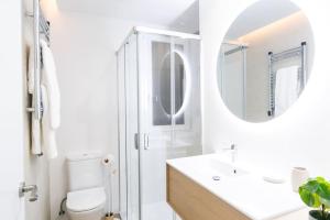 y baño con aseo, lavabo y espejo. en Acogedor y conveniente piso reformado en Salamanca, en Madrid