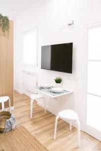 a white living room with a white desk and a tv at Acogedor y conveniente piso reformado en Salamanca in Madrid