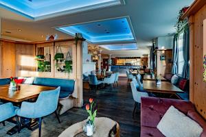 a restaurant with wooden tables and blue chairs at Servus Gelting in Geretsried