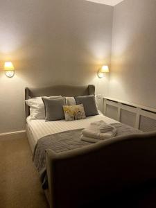 a bedroom with a bed with two lights on it at Dovecote Cottage. in Newcastle upon Tyne