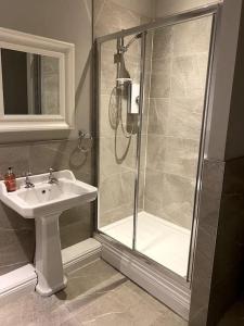 a bathroom with a shower and a sink at Dovecote Cottage. in Newcastle upon Tyne