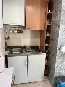 una pequeña cocina con armarios blancos y fregadero en Apartmani Krišto Zadar, en Zadar
