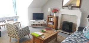 a living room with a couch and a fireplace at Cosy apartment in popular harbour town in Kirkcudbright