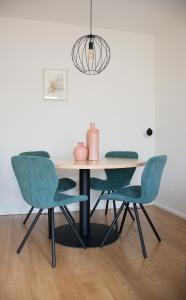een eettafel met vier stoelen en een lamp bij Gastenverblijf Janssen in Schagen (NH) in Schagen